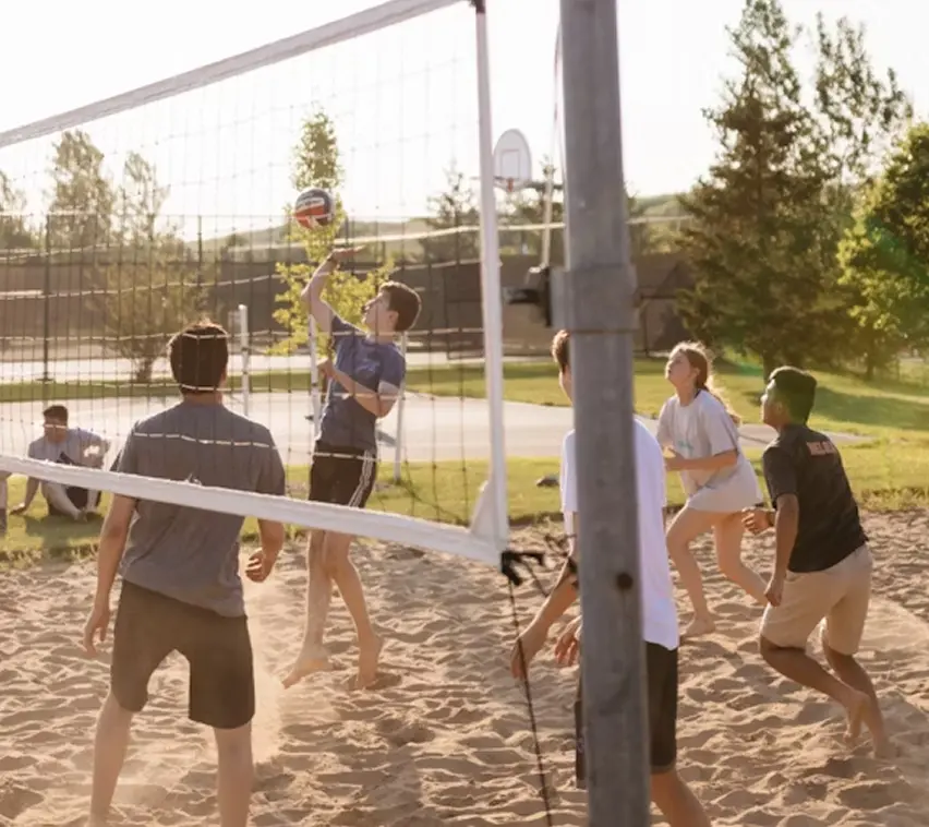 Gruppe spielt Beachvolleyball