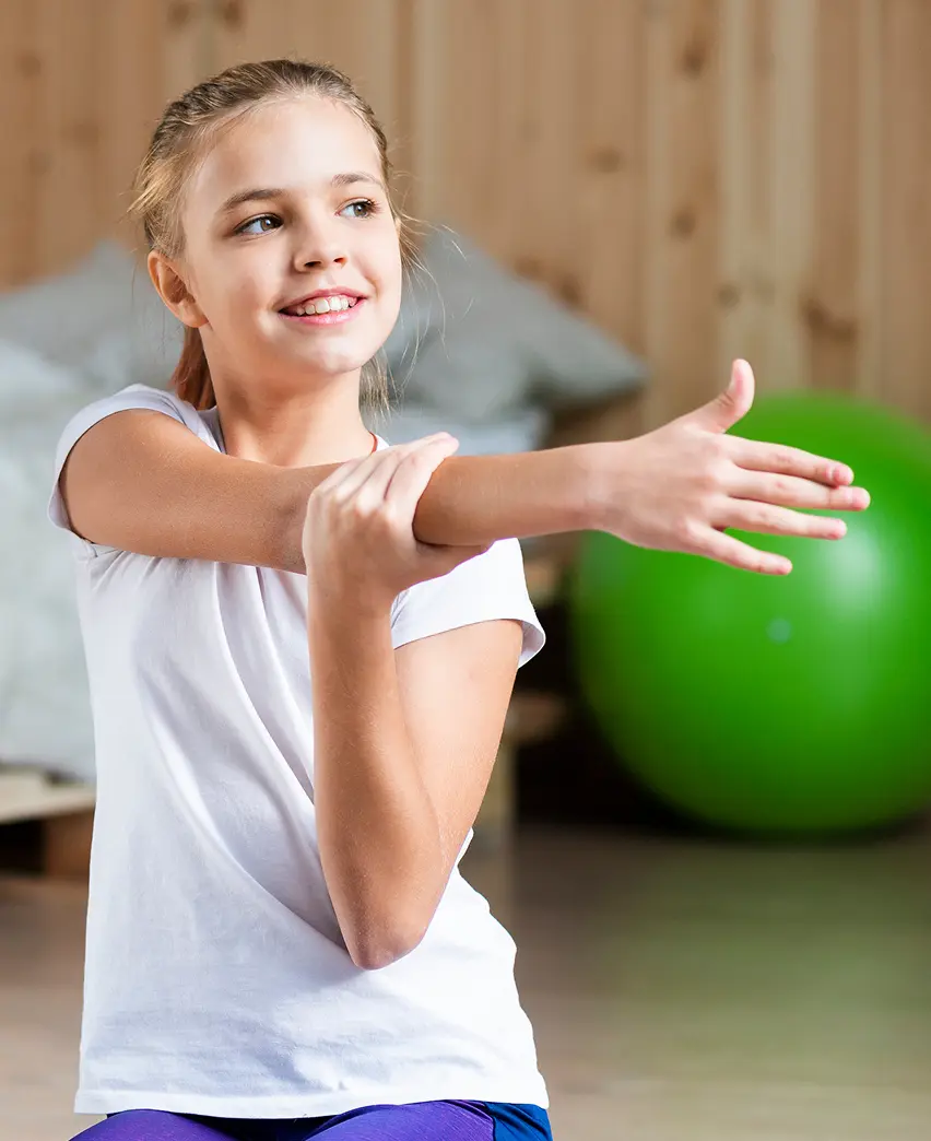 Kind dehnt ihren rechten Arm nach links