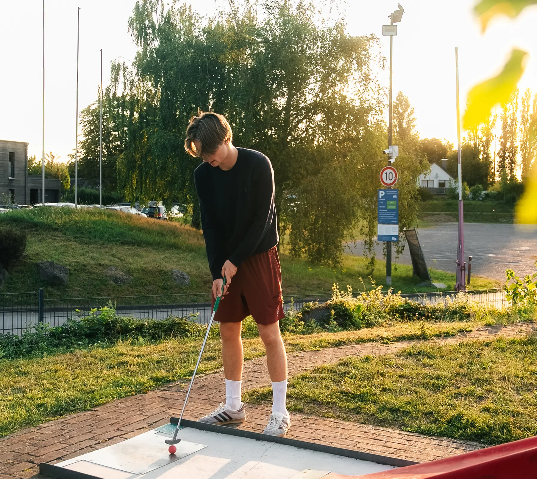 Junge spielt Minigolf