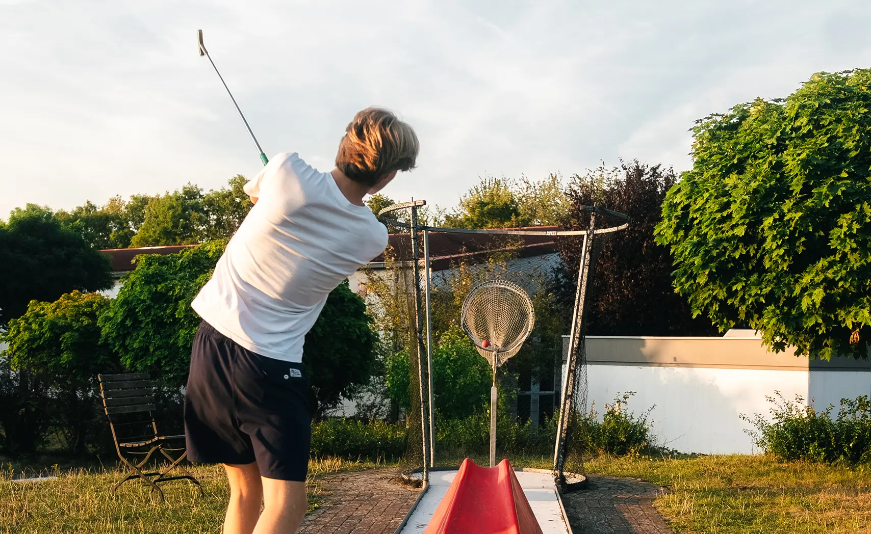 Kind spielt Minigolf