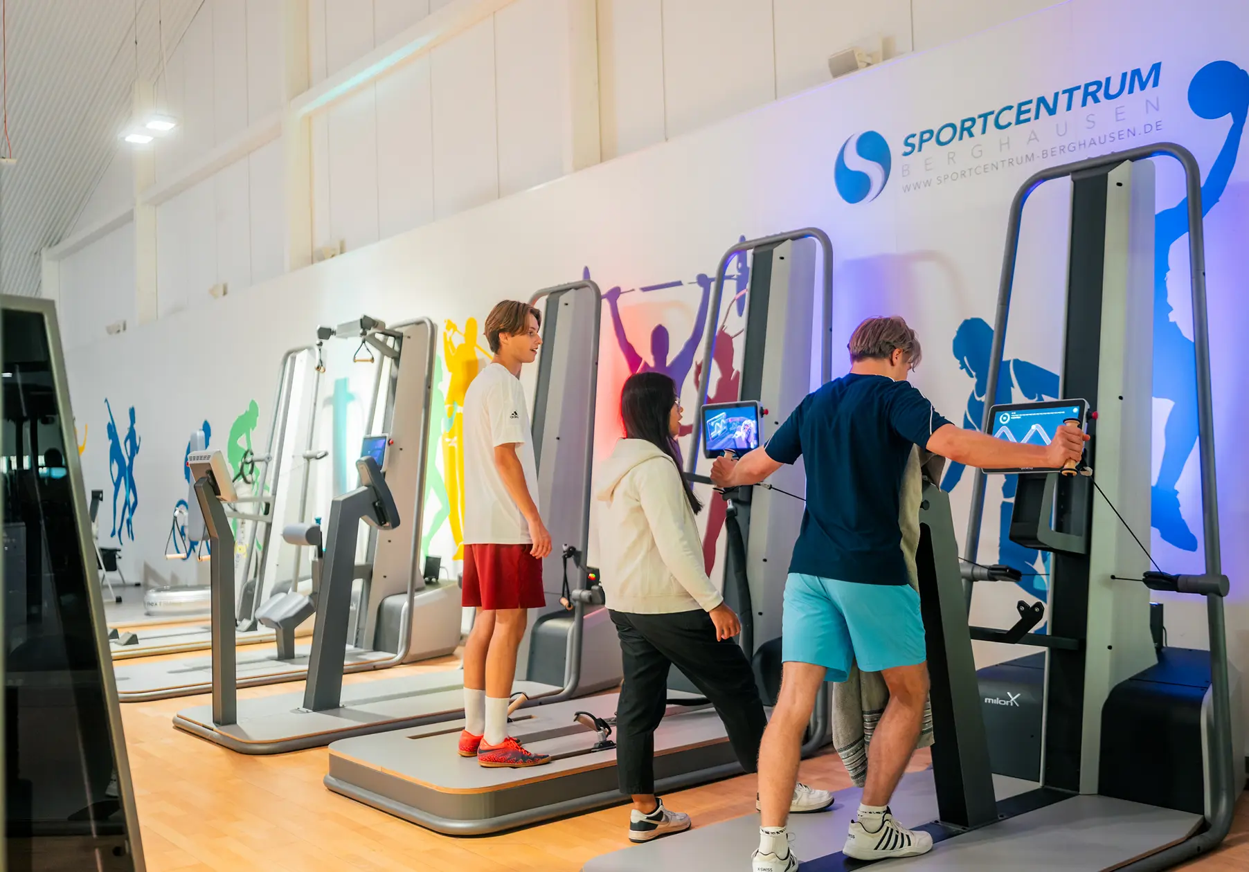 Trainerin berät Kunden im Fitnessstudio