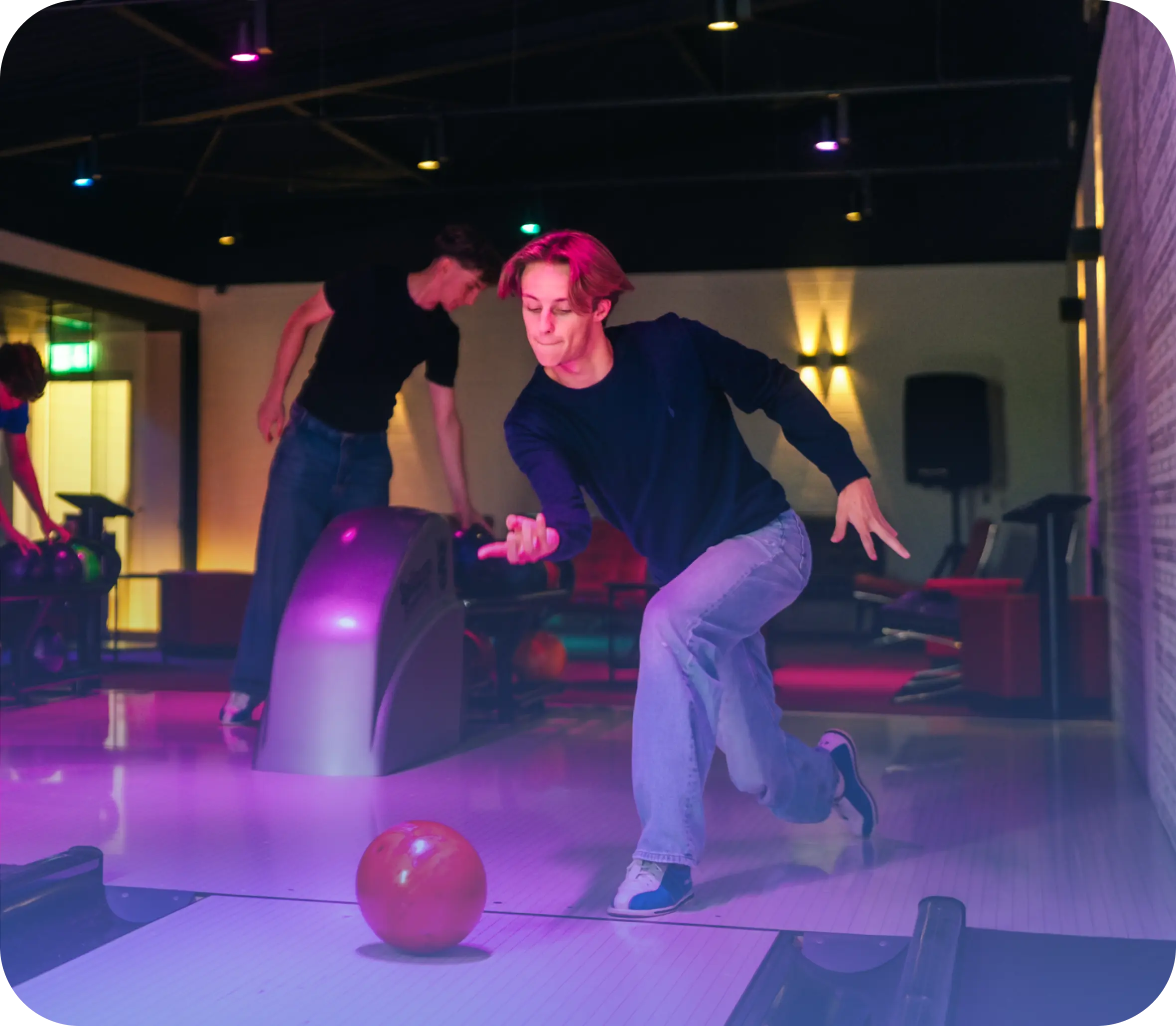 Junge wirft Bowlingkugel auf Bowlingbahn