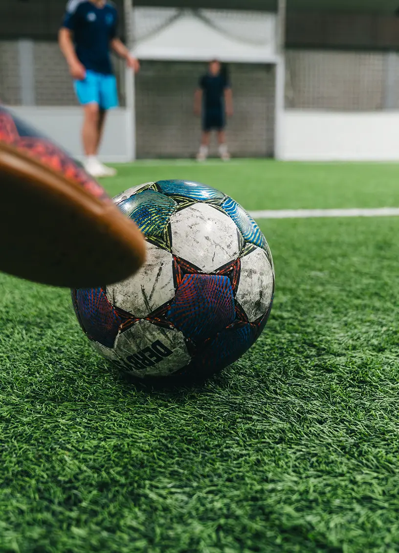 Mann schießt Ball im Indoor Fußball